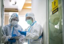 Asian doctor checking coronavirus or covid-19 infected patient in quarantine room