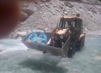 Health workers sitting on JCB 'hands' across river